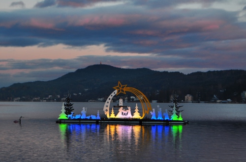 Immagine con presepe, acqua, lago, riflesso, natale, colori, montagne, cometa, luci, natività