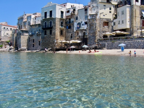 Immagine con spiaggia, mare, case, ombrelloni, acqua, finestre, paese, bagnanti, sabbia