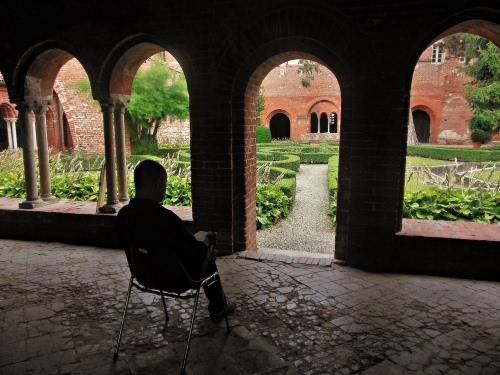 Immagine con archi, sedia, giardino, chiostro, colonne, siepi, persona, aiuole, portico, piante