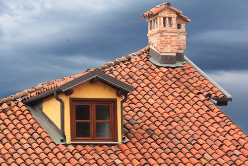 Immagine con tetto, abbaino, tegole, finestra, cielo, nuvole, comignoli, comignolo, camino, coppi