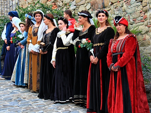 Immagine con donne, costumi, nero, rosso, medioevo, cappelli, fiori, bianco, costume, copricapi, storia, verde, fila, azzurro, sfilata