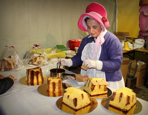 Immagine con cappello, grembiule, dolci, torte, guanti, donna, bianco, biscotti, signora, rosa, rosso, tegame, tovaglia, cibo, pentola, panettoni, pasticciera, cuoca