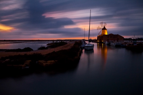 Immagine con mulino, pale, mare, tramonto, acqua, barca, nuvole, cielo, riflessi, vento, saline, barche, alberi, molo, notturno, vela, viola, riflesso, giallo, sera, salina