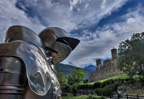 Immagine con armatura, castello, nuvole, alberi, cielo, medioevo, elmo, ferro, torri