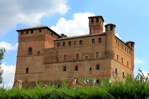 Immagine con castello, bandiere, erba, torre, cielo, finestre, torri, nuvole, verde