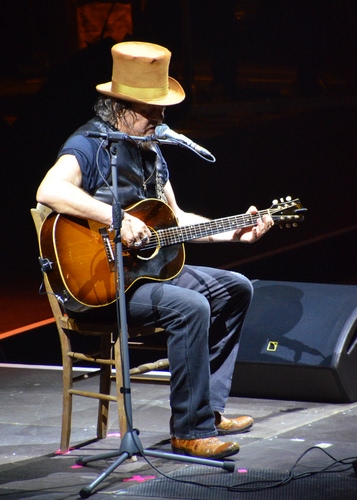 Immagine con chitarra, microfono, sedia, cappello, cantante, musica, zucchero, musicista, chitarrista, palco, concerto, cantautore, cilindro