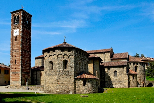 Immagine con chiesa, campanile, cielo, prato, verde, finestre, orologio, torre, croce, croci, archi, tetti