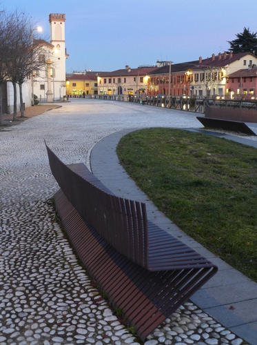 Immagine con panchina, piazza, luci, chiesa, campanile, prato, ciottoli, case, aiuola