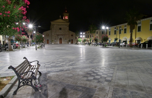 Immagine con panchina, chiesa, piazza, fiori, lampioni, luci, notturno