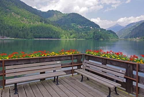 Immagine con panchine, fiori, lago, montagne, acqua, alberi, montagna, terrazza
