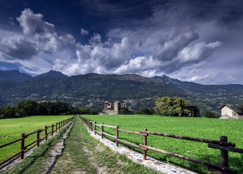 Immagine con strada, nuvole, montagne, staccionata, castello, verde, cielo, staccionate, sentiero, prato, steccato, alberi