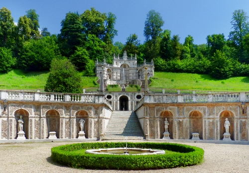 Immagine con statue, verde, alberi, fontana, giardino, nicchie, piante, archi, villa, balaustra, erba, parco, sculture, cielo, scalinata, siepe, scala, reggia