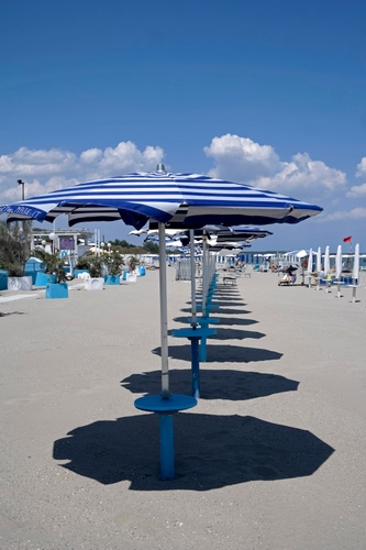 Immagine con spiaggia, ombrelloni, sabbia, nuvole, ombra, ombre, azzurro, blu, cielo