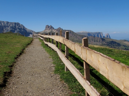 Immagine con sentiero, staccionata, legno, montagne, verde, cielo, azzurro, erba, montagna, strada, prati, vette, sassi, prato