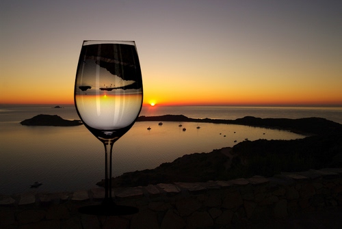 Immagine con bicchiere, mare, tramonto, riflesso, acqua, calice, trasparenza, fotomontaggio, scogli, sole