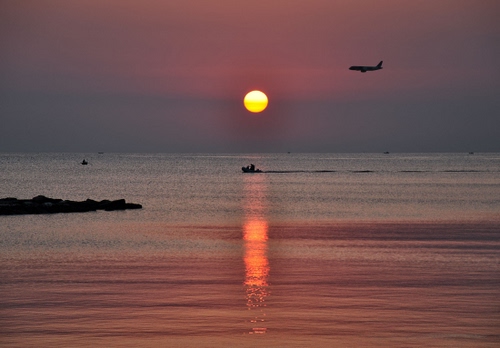 Immagine con mare, tramonto, sole, barca, aereo, acqua, alba, scogli, riflesso