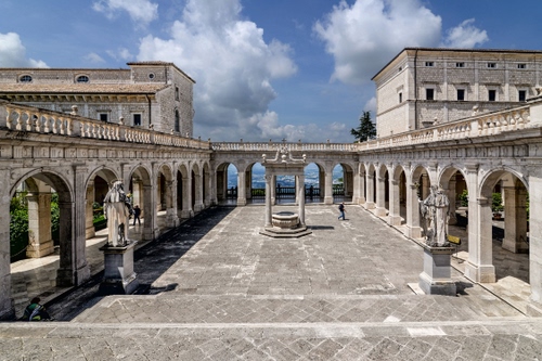 Immagine con pozzo, statue, archi, nuvole, cielo, colonne, palazzi, portici, azzurro, chiostro, balaustra, pilastri, piazza, bianco, porticato, edifici, finestre, mare, abbazia