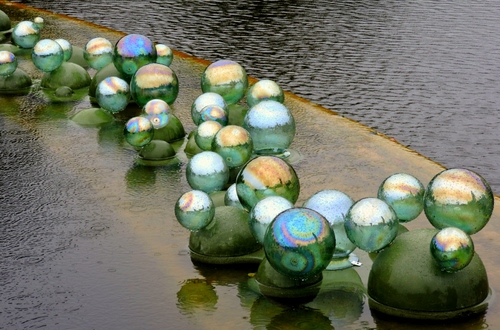 Immagine con sfere, acqua, verde, riflessi, tante, palle, fontana, riflesso, biglie, vetro, azzurro, scultura, vasca, pioggia