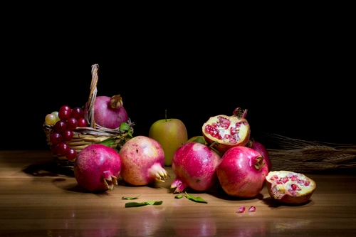 Immagine con melograni, frutta, uva, cesto, spighe, tavolo, mela