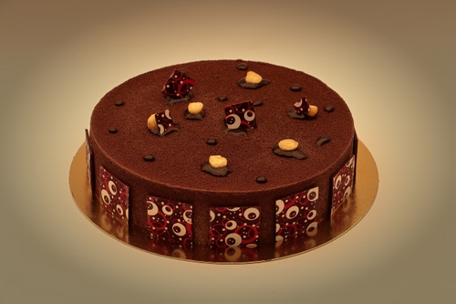 Immagine con torta, dolce, cioccolato, decorazioni, marrone, cerchio, cibo, oro, cacao, dorato, rotondo, riflesso, decorazione, piatto