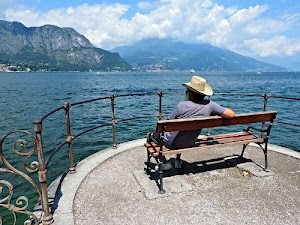 cappello, panchina, nuvole, lago, ringhiera, montagne, uomo, seduto, acqua, spalle, ferro, azzurro, cielo, panorama, barba, terrazzo, legno, mare, monti, ombra