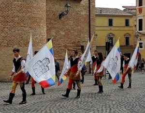 bandiere, sbandieratori, finestre, stivali, case, lampione, sfilata, mattoni, castello, piazza, corteo, costumi, rosso, bianco, rievocazione, ragazzi, giallo, lampioni, paese, medioevo