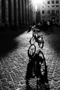bicicletta, ombra, bianconero, controluce, persone, colonne, ruote, raggi, piazza, ombre, selciato, bici, nero, finestre, palazzi, strada, tombini, luce, passanti
